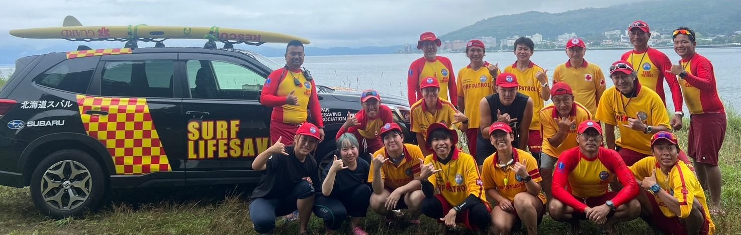 北海道トライアスロン（2023年）の会場で、車両の前に並ぶ札幌ライフセービングクラブのメンバー