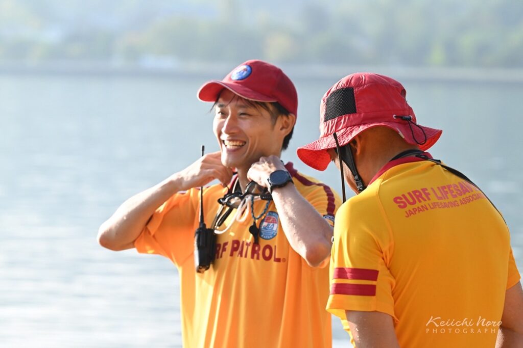 海水浴場で、仲間と笑顔で話す札幌ライフセービングクラブのライフセーバー