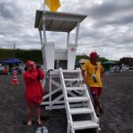 厚田海浜プールの監視台で、双眼鏡で水面を監視するライフセーバーと無線を持つライフセーバー