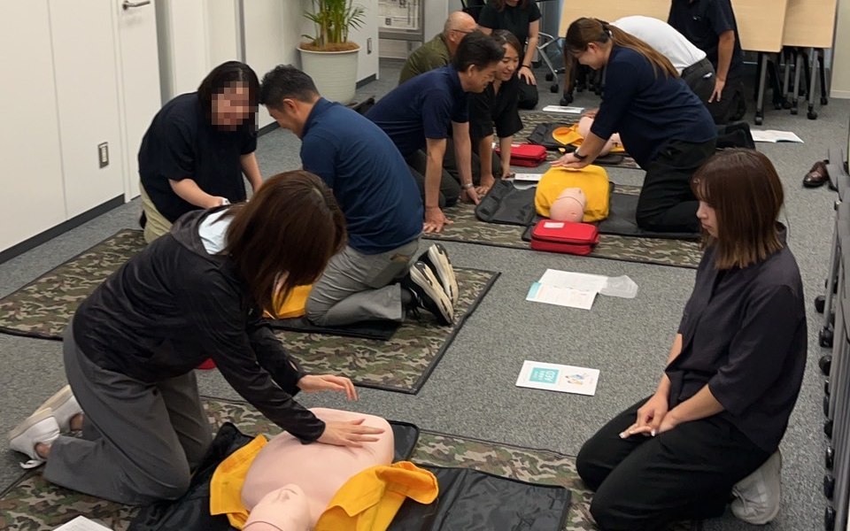 訓練人形とAEDトレーナーを使って、胸骨圧迫とAEDの手順を練習する受講者